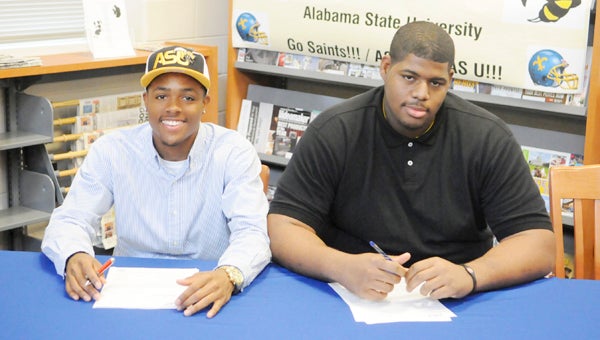 Selma High School’s Davian Brantley, left, and Mark Garrett, right, sign their letters of intent. Brantley will play college football at Alabama State next season, while Garrett will play at UT-Martin.  Each player made huge contributions on a Saints team that reached the postseason and finished the year with a 7-4 overall record.--Daniel Evans