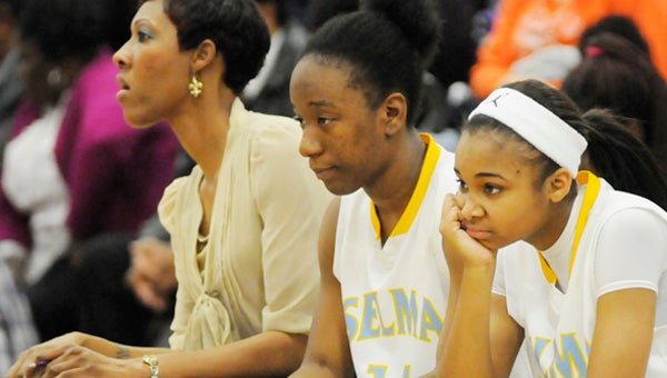 Selma’s Jacquetta Dailey, center, and Jamya Smith, right, look on as Thursday night’s game versus Paul Bryant comes to an end. The Saints lost to Paul Bryant 64-48, which ended Selma’s season.  The Saints end the season with a total record of 24-5.--Daniel Evans