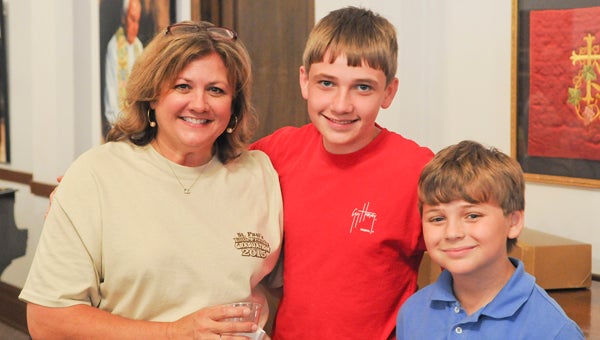 Gina Fuller, director at St. Paul’s Little Friends, poses with former students Grathen Humphreys and Sawyer Wells after graduation ceremony Thursday.--Derek Thompson