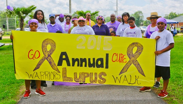 Damyas and D’angelo Coleman hold a banner with participants behind them at the start of the first Warriors Lupus Walk on Saturday at the Alexis Hunter Memorial Park behind Selma High School.