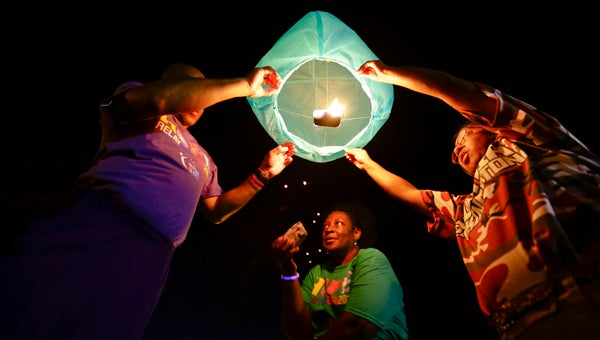  Joyce Harris, center, and two other Relay For Life participants release a sky lantern during Thursday’s event at Lions Fair Park.