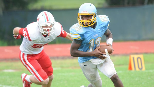 watch out: Selma quarterback Marquell Moorer tries to scramble away from a defender from Hillcrest-Tuscaloosa last year. Moorer is back and competing for the starting quarterback position for the Saints, but also may start on defense this year, according to head coach Leroy Miles.