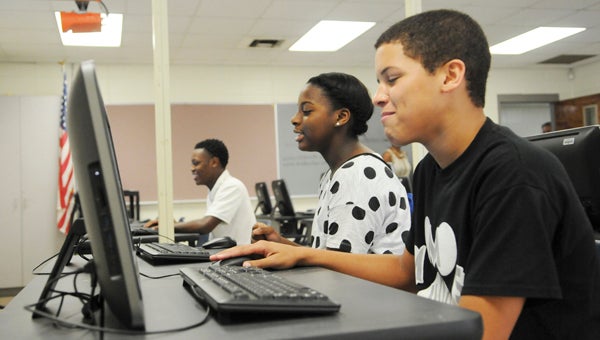 Preston McGee, Marshall McCary and Mar’Trel Chappell play on brand new computers in their seventh grade Martin Middle School computer lab. The computers and all of the equipment were donated by NFL star and Selma native Michael Johnson. 