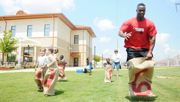 Cincinnati Bengals defensive end and Selma native Michael Johnson, far right, participates during a sack race Saturday during his fourth annual Fun Fest, which was held at Wallace Community College Selma. Johnson also played kickball and other games with the children in attendance. --Daniel Evans