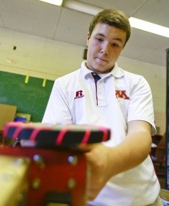 Alek Poe, a sophomore at Morgan Academy, works on his team’s robot. 