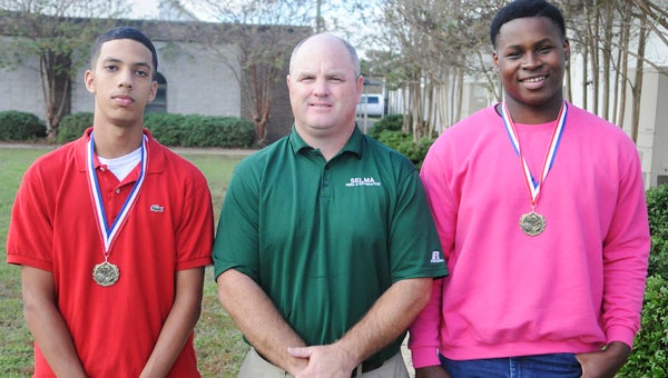 Meadowview Christian’s Sam Dabit and Jevar McGuire stand with Trojans’ head coach Lebo Jones at the school Tuesday.  Dabit and McGuire were named to the Christian Football Association’s all state team. 