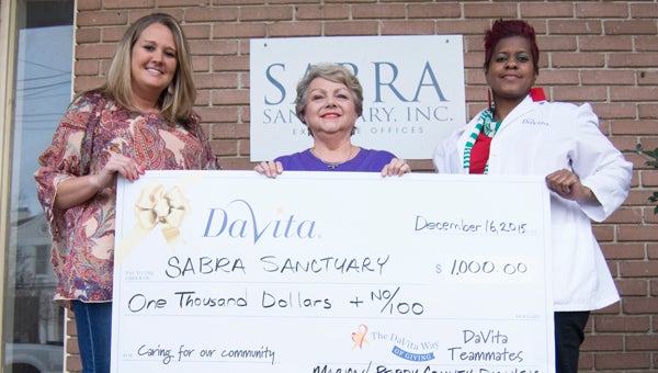Amanda Carter, left, and Sheila Hall, right, presents Nancy Travis, executive director of SABRA, a $1,000 donation Wednesday afternoon. 