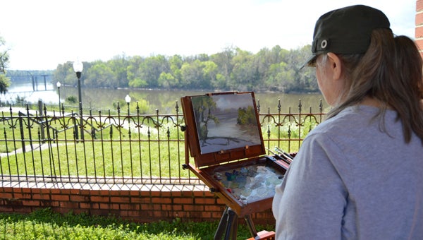 Artist Toska Courbron paints a scene of the Alabama River on Friday. Courbron and other artists were in Selma on Friday to paint local landscapes and buildings as part of the Selma Art Guild’s Wet Paint Sale.