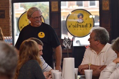 Owner Charlie Morgan is shown with restaurant patrons.