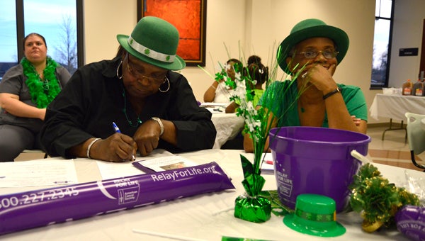 Viola J. Dudley and Regina Woodson complete paperwork during a Relay For Life team rally Tuesday. 