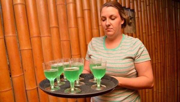 Tally Ho owner Renee Wilkerson walks out to distribute green Champagne to guests during the annual St. Patrick's Day Benefit Dinner on Thursday.