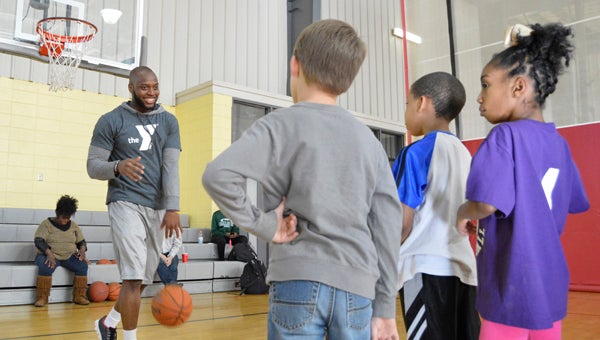 Fitness coordinator Darion Alexander shows Cren Thornton, 7, Jaterious Levins, 8, and Markia Evans, 7, a drill during “Drills and Skills,” at the YMCA of Selma-Dallas County on Monday. -- Emily Enfinger
