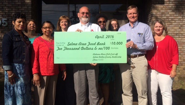 Christy Thomas, Becky Glaze, Ivy Harrison, Dewauna Vinson, Ebony Rose, Jessica Hope, Todd Stewart and Leslie Free present Selma Area Food Bank executive director Jeff Harrison with a $10,000 donation. The money was raised during the fifth annual Alabama River Chili Cookoff.