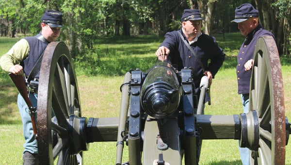 Civil War re-enactors prepare to fire a cannon at a service to honor soldiers Friday at Old Cahawba Archaeological Park. The site housed Castle Morgan, a Union prisoner of war camp in the 1860s. The prison had the highest survival rate of all Civil War POW camps. 