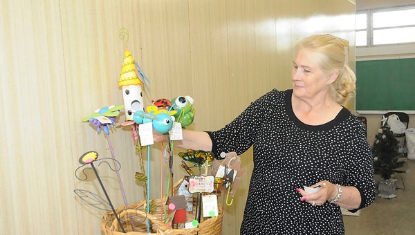 Betty Miller puts a price tag on yard decorations that the Queen of Peace Catholic Church will sell Friday in the Historic U.S. Highway 80 Sale. — Chelsea Vance