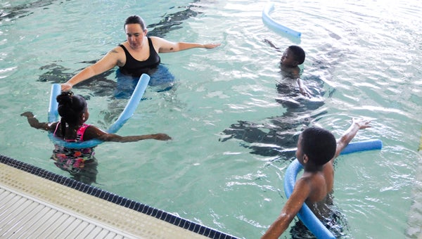  Instructor Skyler Hysler teaches Taylor Rose, 8; Calvin Roberts, 8; and Jaylen Hayes, 11, how to do the plane stance and float on their backs during a water safety course Tuesday at the YMCA of Selma and Dallas County. The YMCA is partnering with local schools for the free classes. 