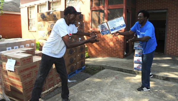ive Point Community Development Center volunteers Clarence Watts (left) and Calvin Weeks (right) unload a food truck at the center Thursday. 