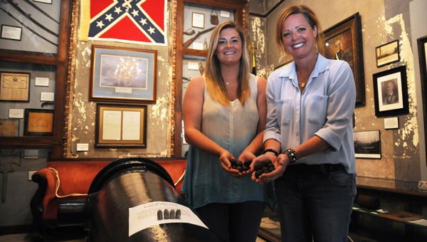 Catherine Gordon and Old Depot Museum curator Beth Spivey pose with recently donated Civil War cannon ball shots and bullets Monday. Gordon’s father, Robert, donated the weapons to help expand the museum’s collection of local history.