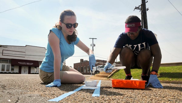 University of Alabama students 18-year-old Gracie Thull and 19-year-old Alyssa Barefield paint parking lines outside the Perry County Courthouse in Marion on Wednesday.