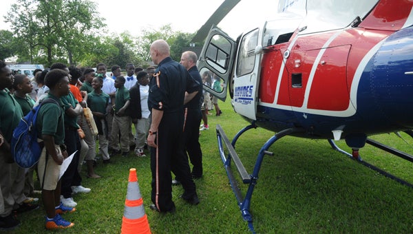 Jaquarius Ford, Jayln Jones and Amir Muhammad ask questions to Haynes Life Flight crew members Jerry Plyler and Mack Ward during School of Discovery’s career fair Tuesday. 