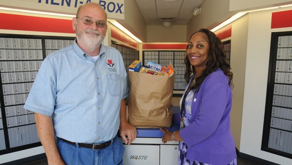  Selma Area Food Bank executive director Jeff Harrison and postmaster Chandra Fleming pose for a photo with a bag of groceries. The annual Stamp Out Hunger food drive will be held Saturday, May 14 and will benefit the Selma Area Food Bank.
