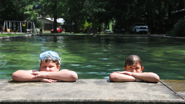 Walt Bowline, 8, and Whitt Bowline, 9, pose for a photo at the edge of their family’s pool. The 81-year-old pool is fed through a artesian well. 