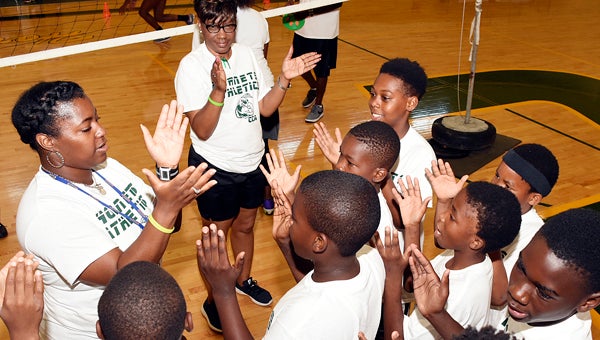Above, Concordia College Alabama volleyball coach Katasha Turner claps in a huddle with campers during Tuesday’s All Day Sports Camp.  Below, Michael Brown hops throiugh an agility drill during the football portion of the camp.  — Daniel Evans