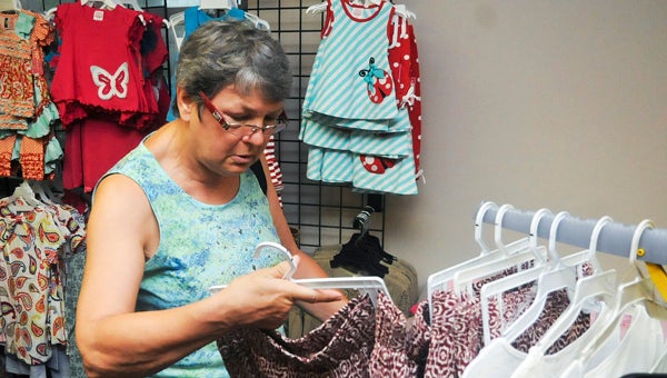 Kathleen Smith takes a closer look at a pair of pants at the Britches and Bows “Love These Clothes” sale Wednesday.