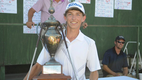 Riley Thrasher, 16, holds the Bud Burns Dixie Junior Championship trophy after hitting a 221 in the 54-hole tournament to win. — Justin Fedich