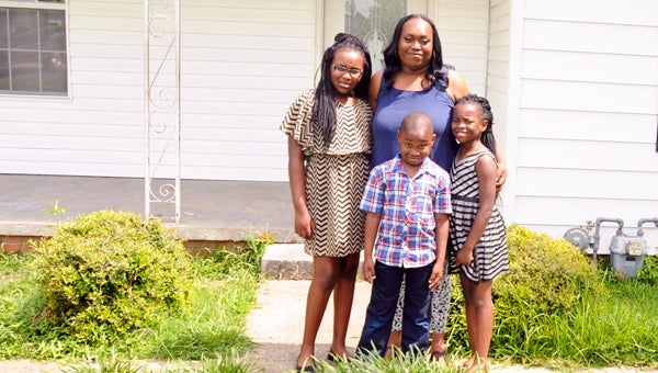 The Johnson family has moved back into their home after a house fire in February. Tiffany Johnson is pictured with her three children Makayla,11, Malik, 6, and Tamyah, 8, who woke her mother up the night of the fire, allowing her family to escape the blaze. 