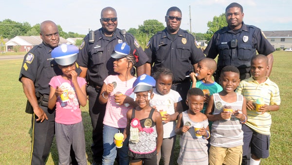  From left to right are Sgt. Tony Neely, Officer Nathan Gibson, Detective Ray Blanks and Officer Mario Rose of the Selma Police Department with children of Chanticlear Apartments on a community policing detail Friday. 