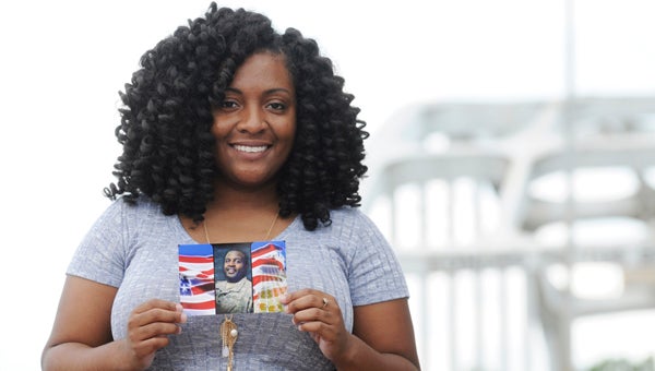 Jasmine Jones, 25, holds a photo of her brother, Sgt. Ricky “Mojoe” Jones, who was killed seven years ago in Afghanistan.  --Emily Enfinger