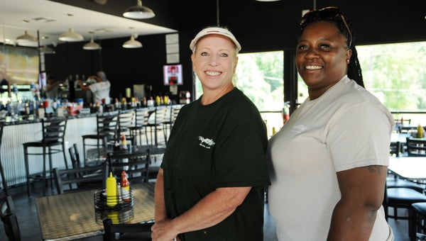 Kim Morris, manager, and Trina Brown, kitchen manager, pose for a photo at The Sand Bar restaurant Monday. The restaurant had a soft opening on Saturday and will be officially be open for business Wednesday. 