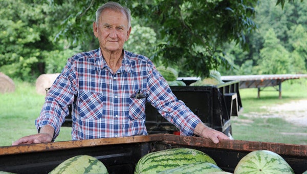 Ronnie Adams, 79, poses for photos with his watermelons.  --Emily Enfinger