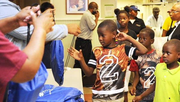 Anthomy Satwhite, 7, reaches for a drawstring bag at the Edmundite Missions’ “Slice of Hope” party Tuesday.  