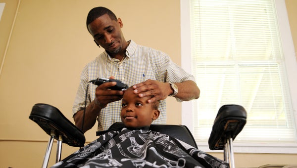 Ethan Richardson, 6, gets his hair cut Wednesday by barber Robert Sullivan with Teamwork Barber Shop at the Orrville Community Center.