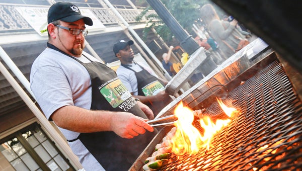 Jeremy Ross cooks during the 2015 Wild Game Cook-Off on Water Avenue. -- File Photo