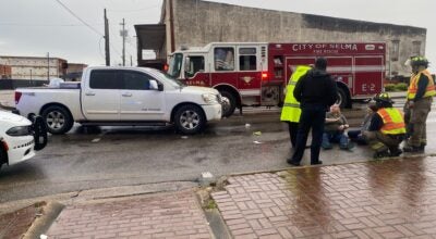 First responders care for two pedestrians who were hit by a pickup truck crossing Broad Street at the foot of the Edmund Pettus Bridge Tuesday morning.
